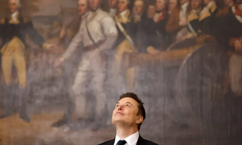 Elon Musk looks up at a large historical painting featuring founding fathers.