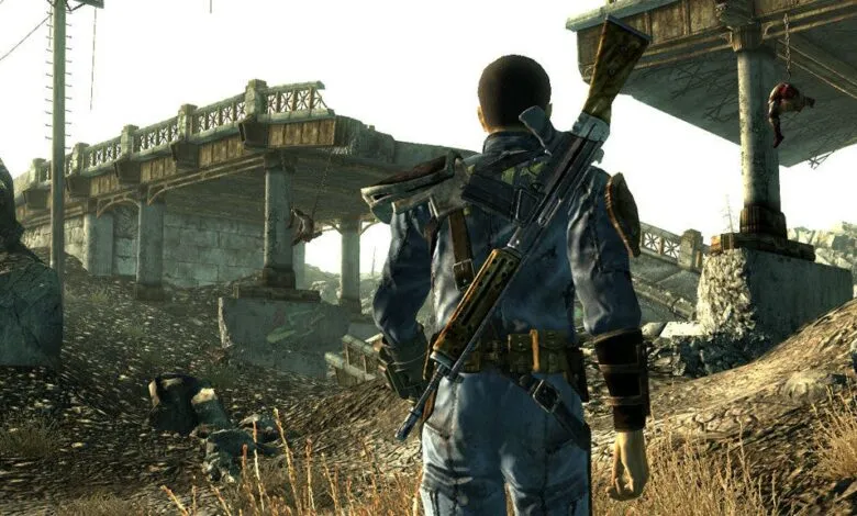 A character in a blue jumpsuit with a rifle slung over their shoulder stands in a desolate, post-apocalyptic landscape.