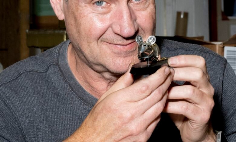 Jeff De Boer holds a miniature suit of armor for a mouse.
