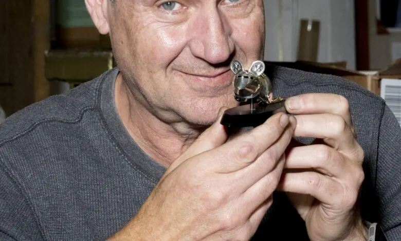 Jeff De Boer holds a miniature suit of armor for a mouse.