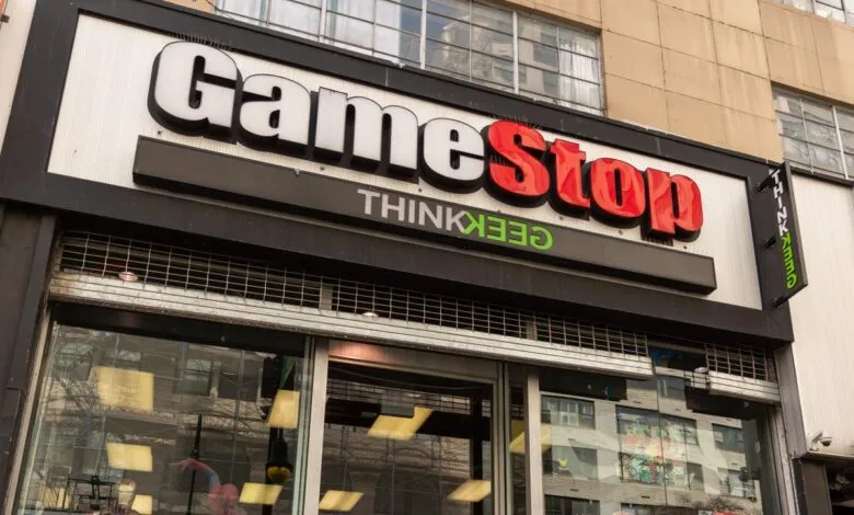GameStop store facade with illuminated logo and ThinkGeek sign.