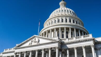 Close-up view of the U.S. Capitol building dome and facade against a clear blue sky.