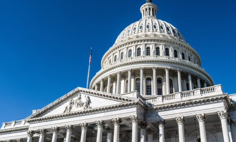 Close-up view of the U.S. Capitol building dome and facade against a clear blue sky.