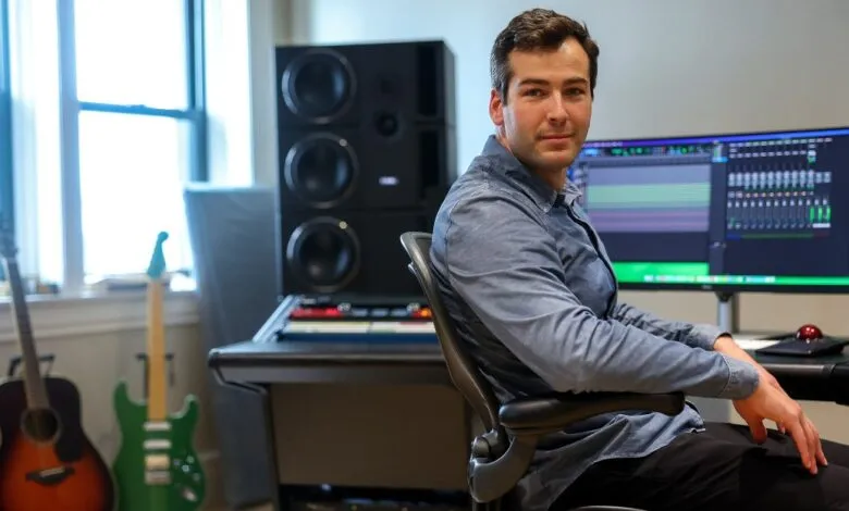 Man in a recording studio with guitars and audio equipment