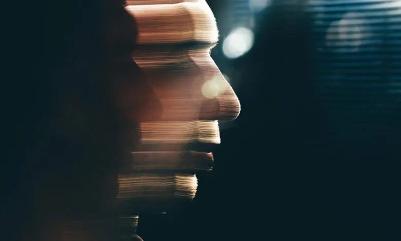 Profile of a person's face with horizontal light streaks, suggesting motion or distortion.