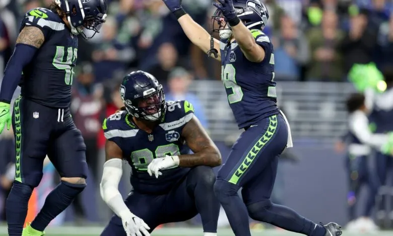 Seattle Seahawks players in uniform celebrating on the field during a game.