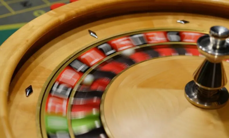 Close-up of a spinning roulette wheel with blurred red, black, and green pockets.