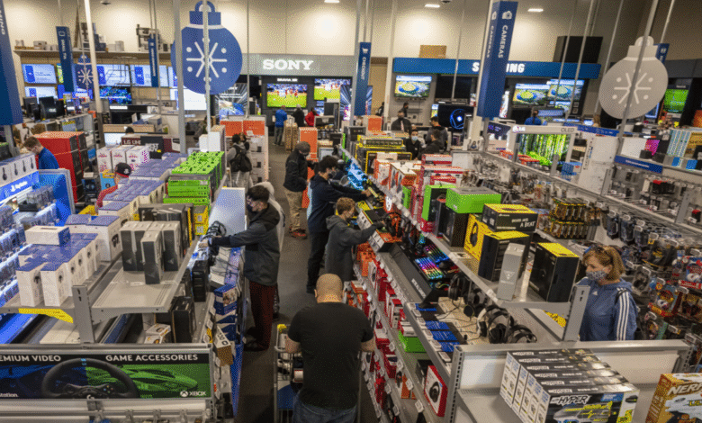 Busy Best Buy store aisle with customers shopping for electronics.