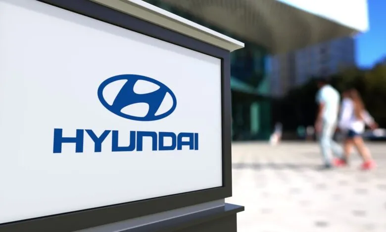 Close-up of a Hyundai logo and name on a backlit sign.