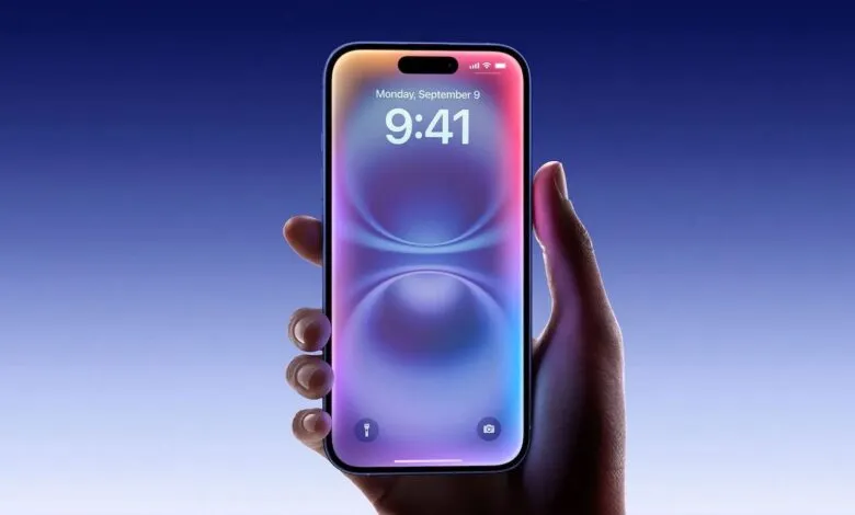 Hand holding an iPhone displaying the lock screen with time and date.