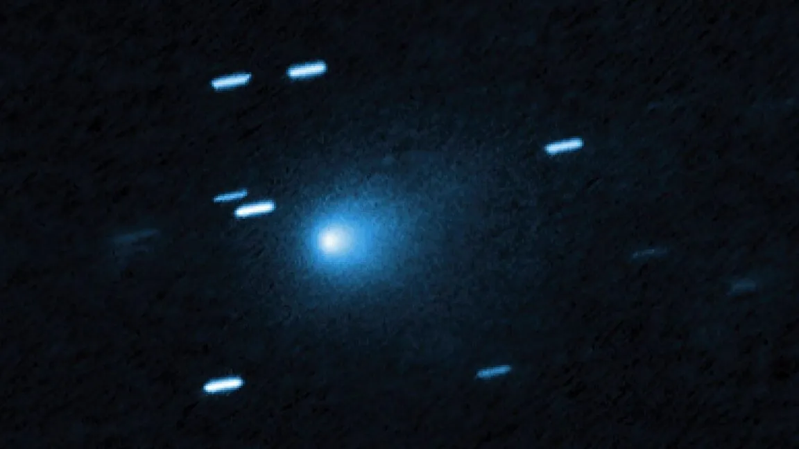 A bright blue comet with a glowing nucleus against a dark, star-filled sky.