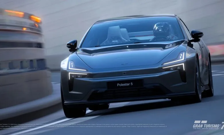 A dark gray Polestar 5 electric car driving on a race track with motion blur.