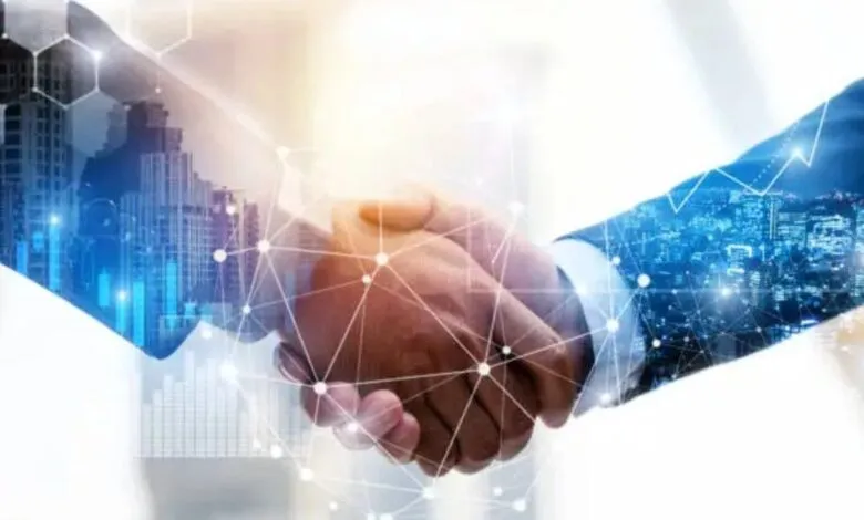 Two business professionals shaking hands with a digital network overlay.