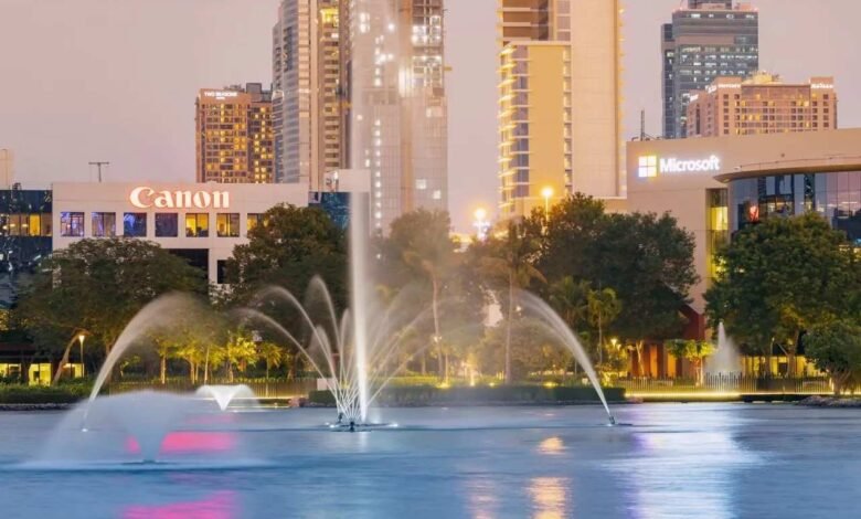 Water fountains spray in a lake with Canon and Microsoft buildings in the background at dusk.