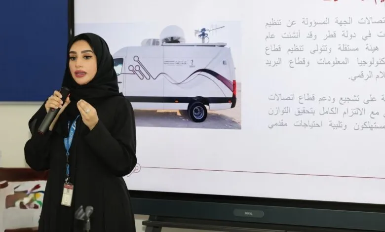 Woman in hijab speaking into a microphone, with a presentation slide showing a broadcast van.