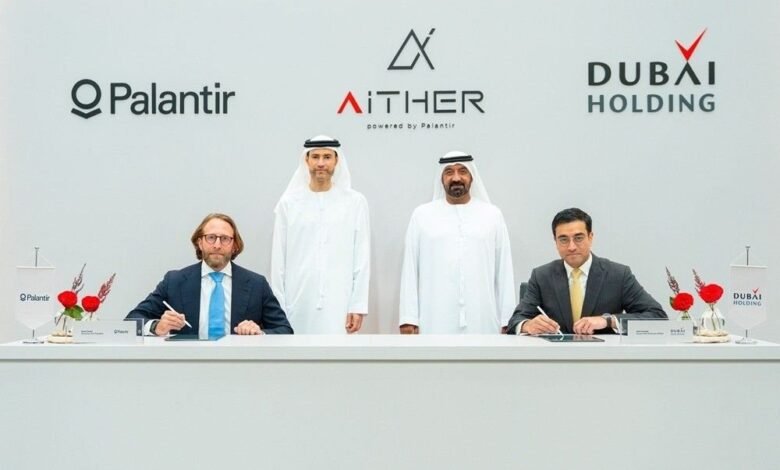 Four men in formal attire signing documents at a table with company logos in the background.
