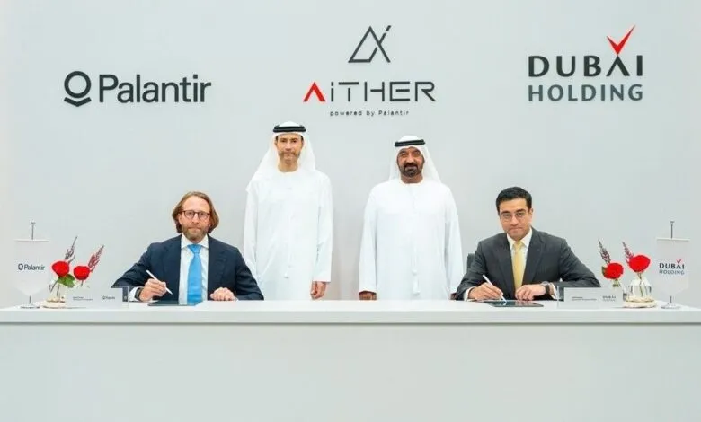 Four men in formal attire signing documents at a table with company logos in the background.