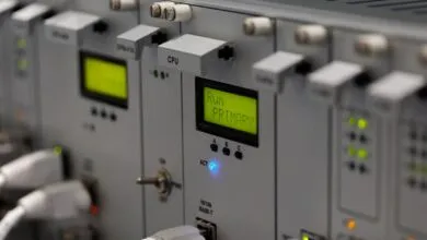 Close-up of a rackmount industrial control system with illuminated displays and status lights.