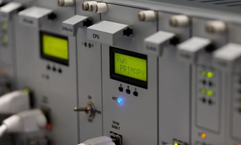 Close-up of a rackmount industrial control system with illuminated displays and status lights.