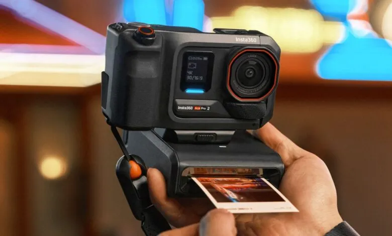 Close-up of a person holding the Insta360 Ace Pro 2 camera with a printed photo emerging from its base.