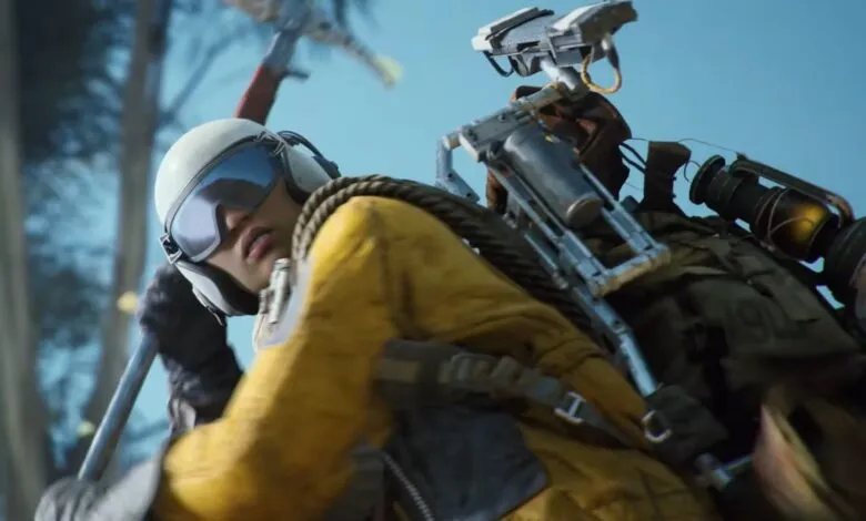 A person in a yellow jacket and white helmet with goggles, carrying a backpack with equipment.