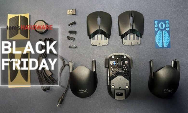 Disassembled HyperX Pulsefire Haste 2 mouse parts laid out on a dark surface.