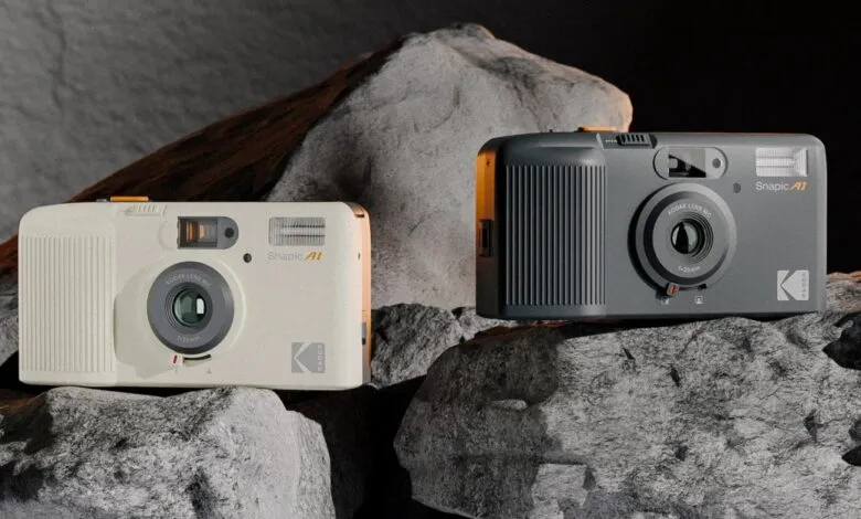 Two Kodak Snapic A1 cameras, one cream and one gray, sitting on rocks.