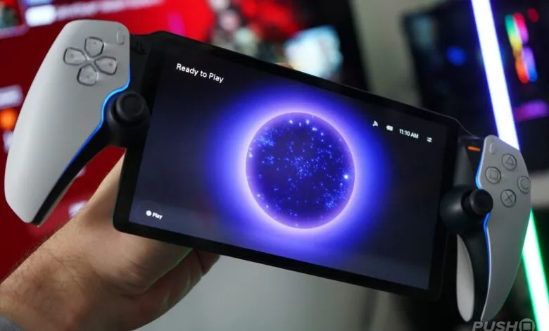 Hand holding a PlayStation Portal device with a glowing purple orb on screen.