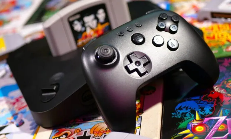Nintendo 64 console, controller, and game cartridges on a colorful surface.