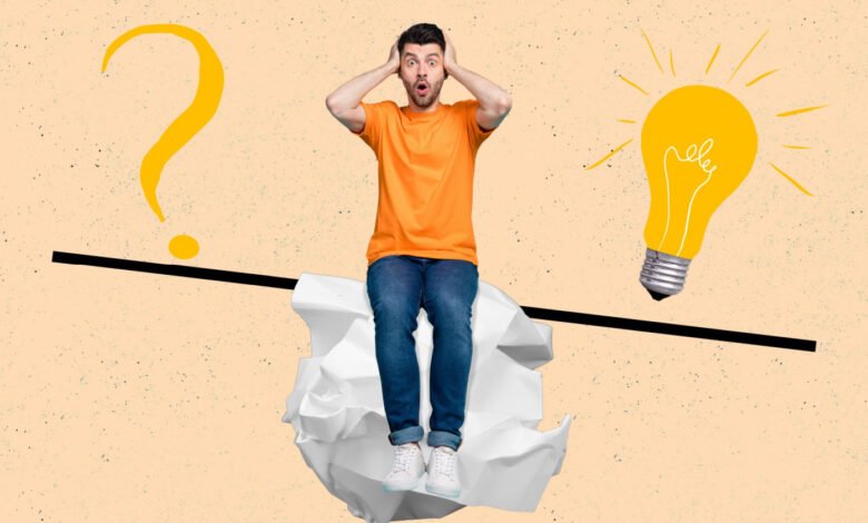 Man with hands on head looking shocked, sitting on crumpled paper, between a question mark and a lightbulb.