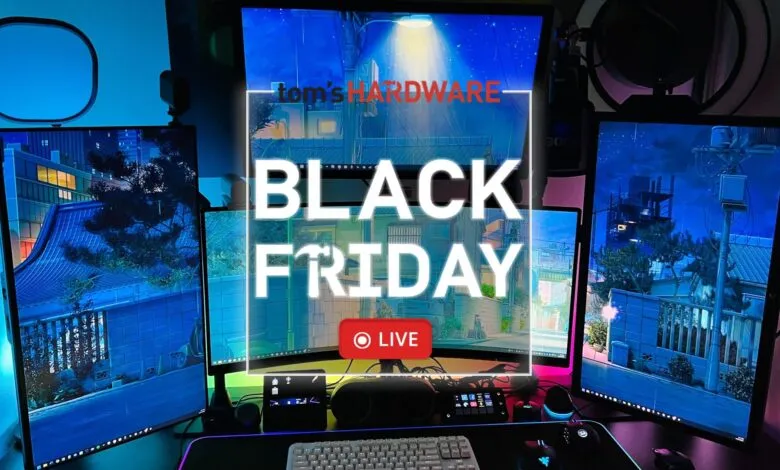 Gaming setup with multiple monitors displaying Black Friday ad and cityscape.