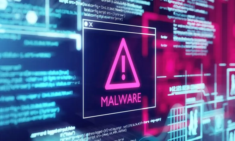 Digital screen displays a warning sign and the word MALWARE in pink, surrounded by code.
