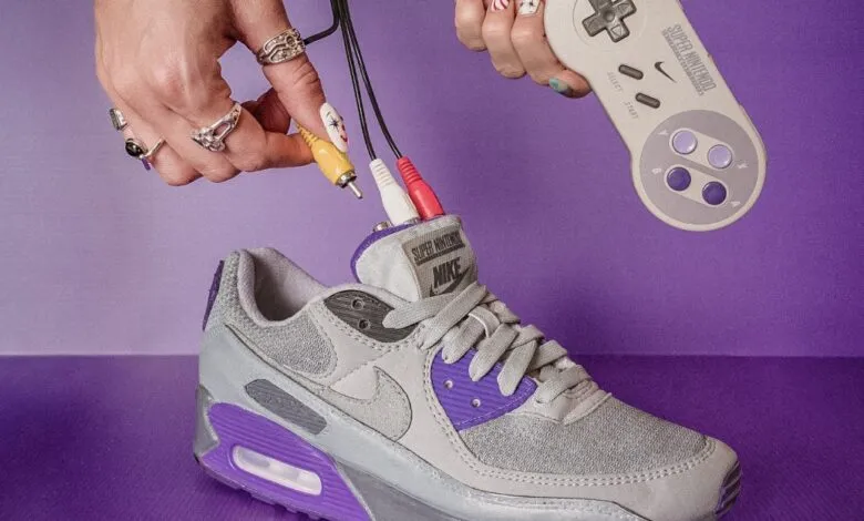 Nike Air Max sneaker with SNES controller and AV cables on purple background.