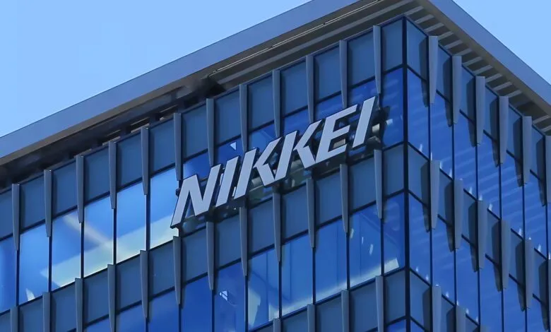 Nikkei logo on a modern glass building facade against a clear blue sky.