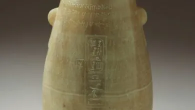 Close-up of an ancient alabaster vessel with hieroglyphic inscriptions.
