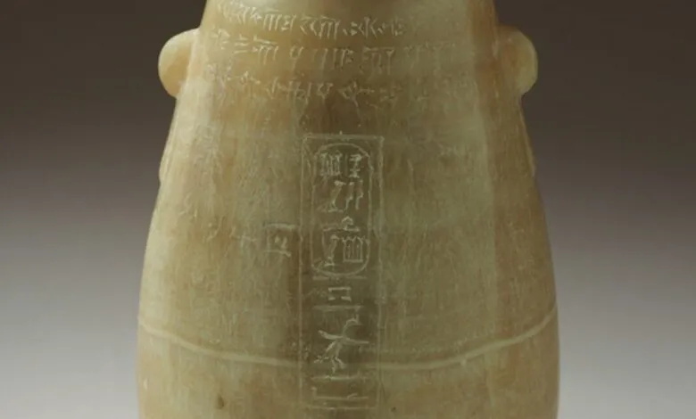 Close-up of an ancient alabaster vessel with hieroglyphic inscriptions.