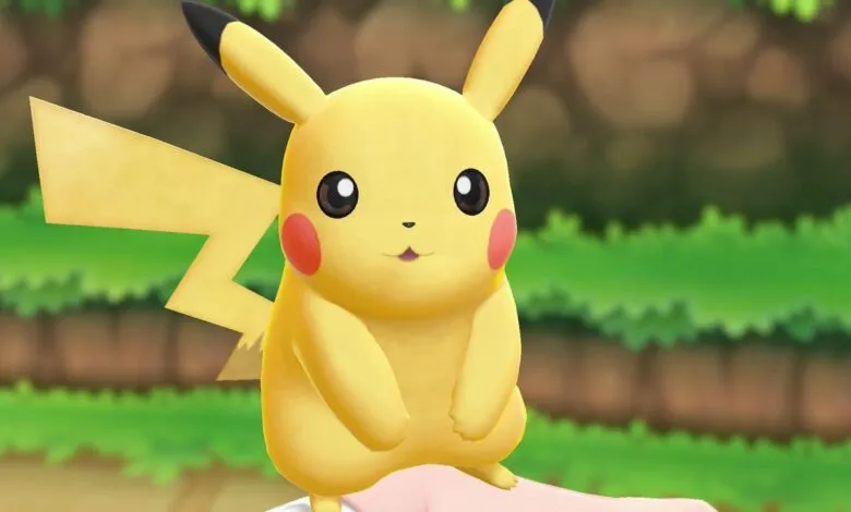 Pikachu, the electric mouse Pokémon, sits in a grassy outdoor environment.