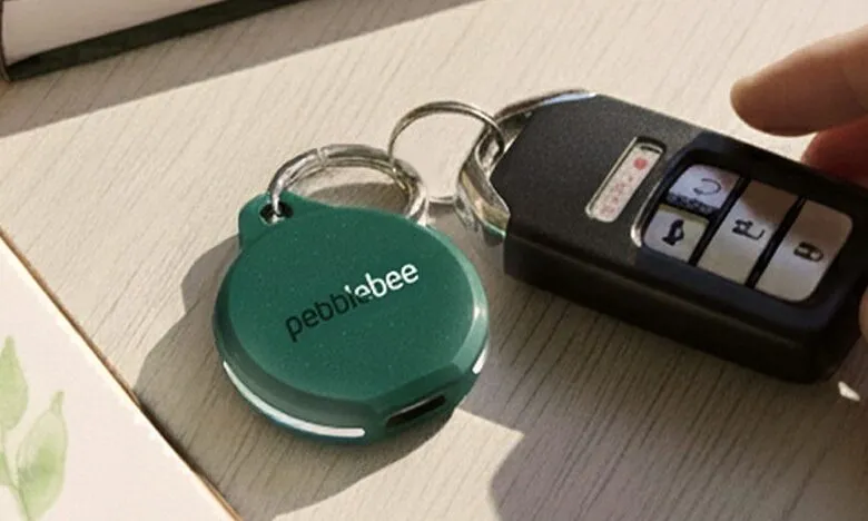 A green Pebblebee tracker attached to a car key fob.