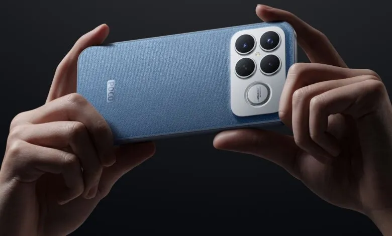 Hands holding a blue denim-textured smartphone with a quad-camera setup.