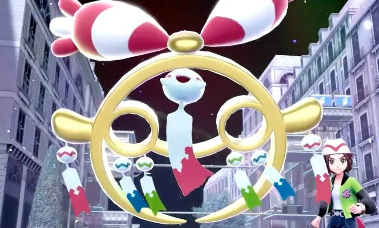 A young woman in a green jacket and hat stands next to a large, ornate golden wind chime with colorful streamers.