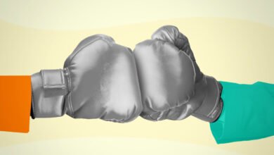 Two boxing gloves, one orange and one teal, clashing in the center.