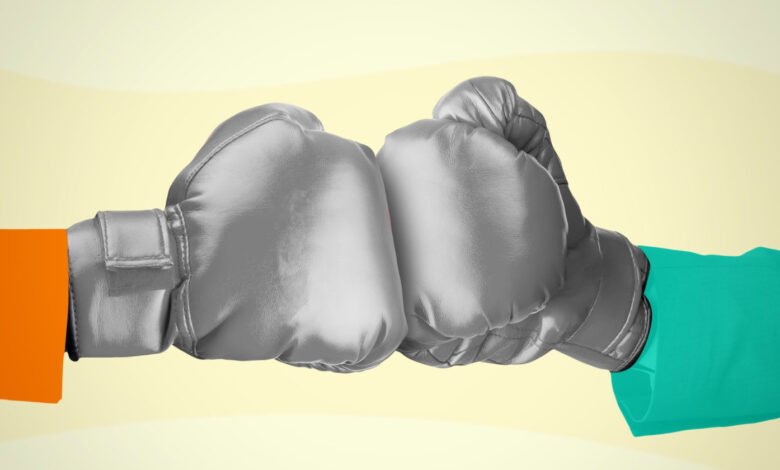 Two boxing gloves, one orange and one teal, clashing in the center.