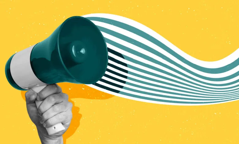 Hand holding a teal and white megaphone with sound waves emanating