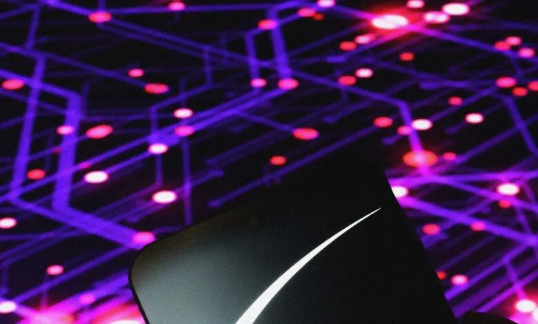 Close-up of the SpaceX Starlink logo against a blurred background of purple and pink lights.