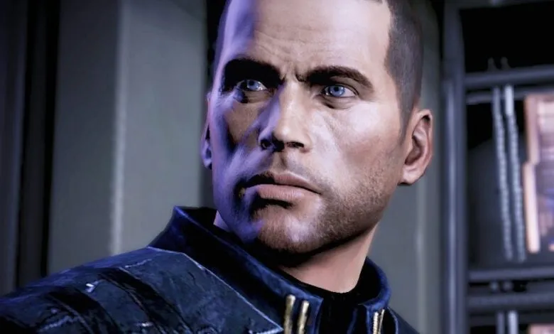 Close-up of Commander Shepard's face, a human male with blue eyes and short brown hair.