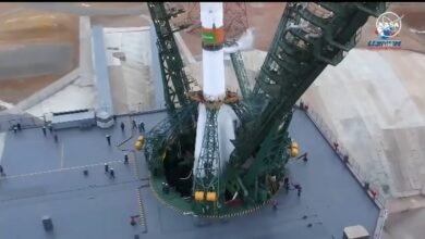 Soyuz rocket on launchpad with support structure, NASA logo visible.