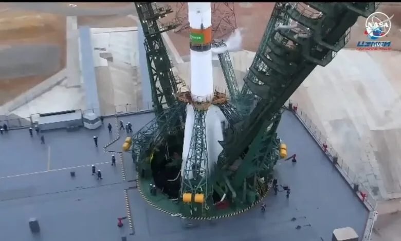 Soyuz rocket on launchpad with support structure, NASA logo visible.
