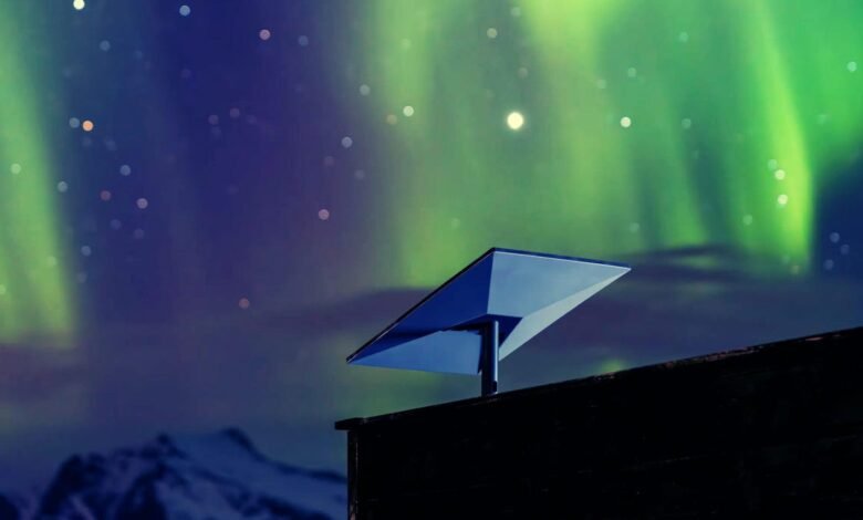 Starlink dish on roof with aurora borealis and starry night sky.