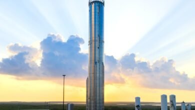 SpaceX Starship stands tall against a vibrant sunset sky.