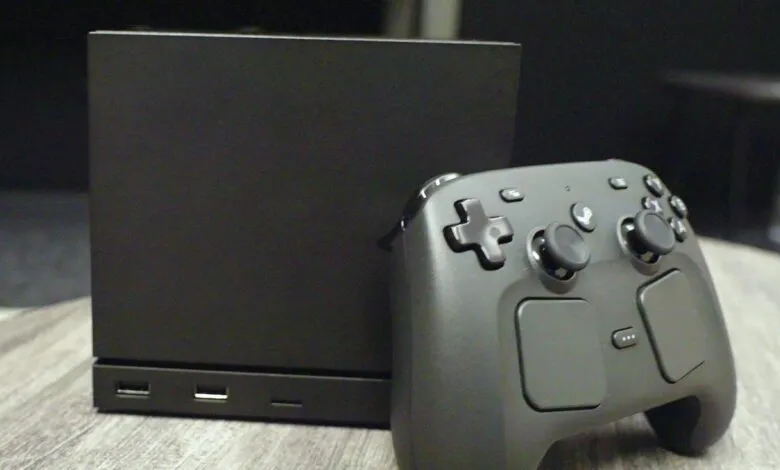 Steam Machine and controller on a wooden surface.